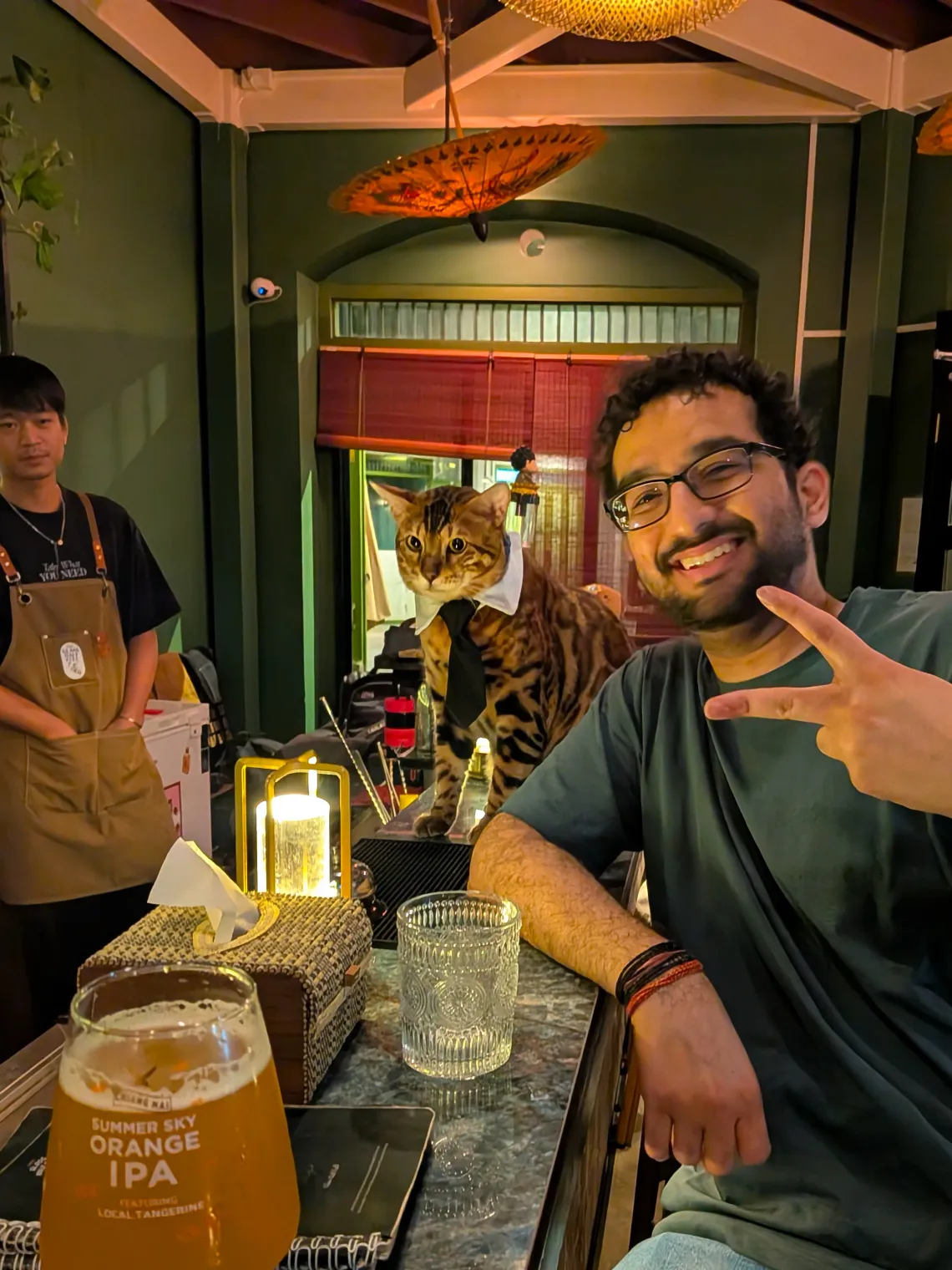 Parth and a large Bengal cat named Cren hang out in the Glass half Full, Bangkok.